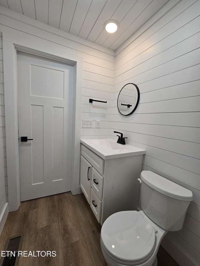 bathroom featuring visible vents, toilet, wood ceiling, wood finished floors, and vanity