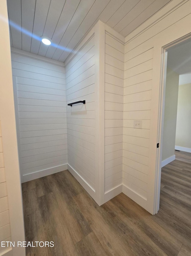 interior space with wood walls, baseboards, and wood finished floors