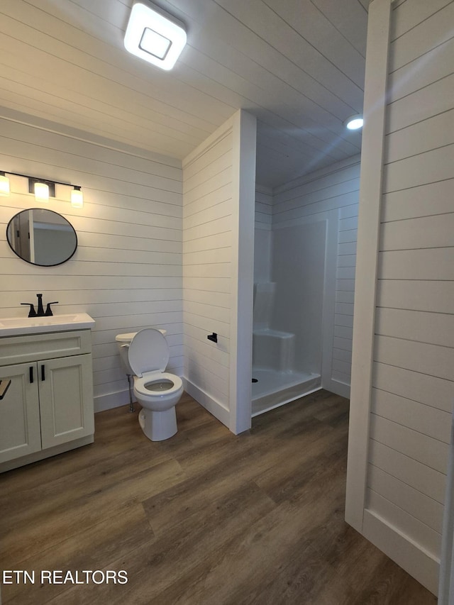 full bath featuring vanity, wood finished floors, toilet, and a shower stall