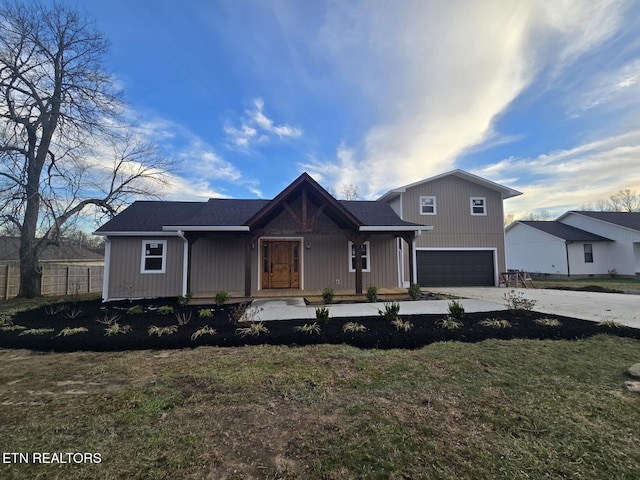 view of front of property with covered porch, a front yard, fence, a garage, and driveway