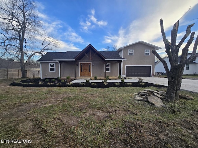 view of front of home featuring a garage, covered porch, fence, driveway, and a front yard