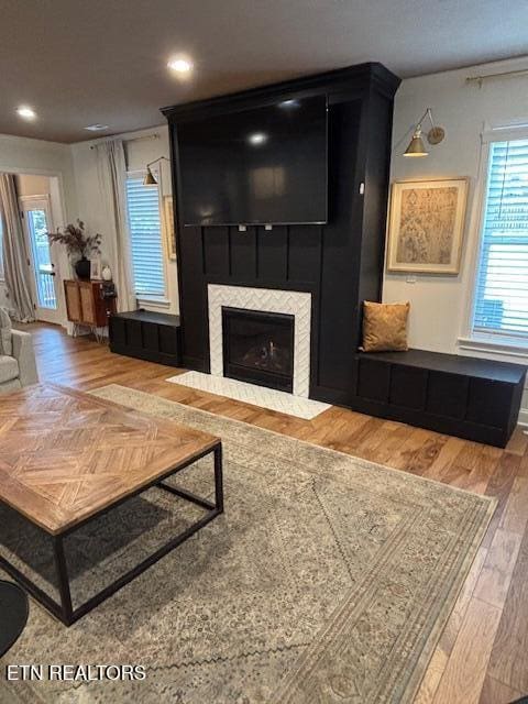 living room with hardwood / wood-style floors, a wealth of natural light, and a fireplace