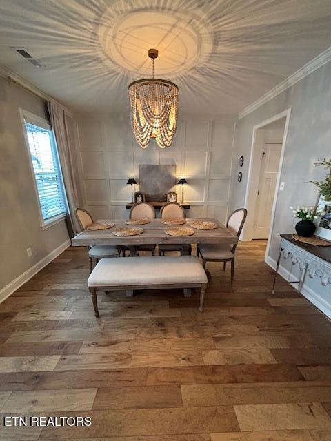 dining space featuring a notable chandelier, crown molding, and dark hardwood / wood-style floors