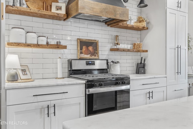 kitchen with open shelves, custom exhaust hood, gas range, and tasteful backsplash