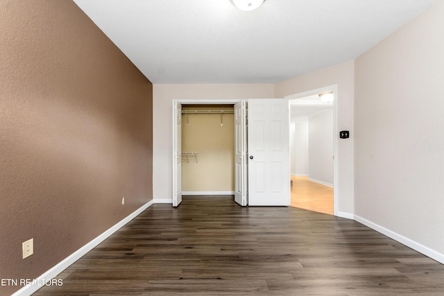 unfurnished bedroom with dark hardwood / wood-style flooring and a closet