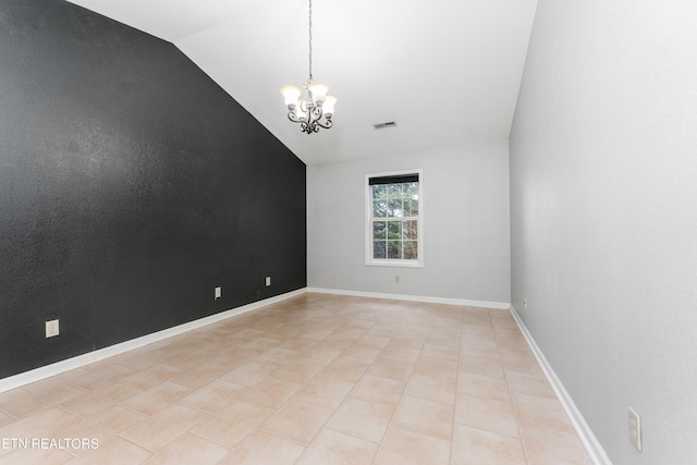 empty room featuring light tile patterned floors, vaulted ceiling, and a chandelier