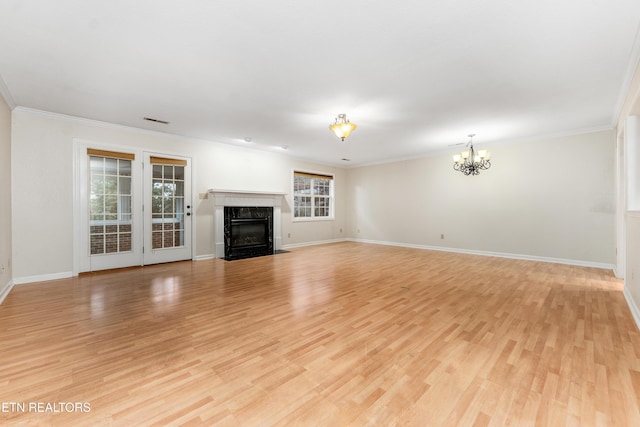 unfurnished living room with ornamental molding, a chandelier, a fireplace, and light hardwood / wood-style floors