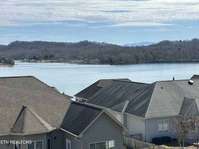 property view of water with a view of trees and fence