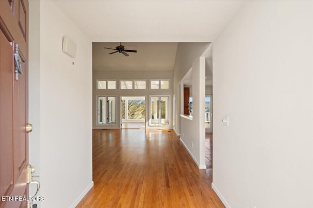 hallway with baseboards and light wood finished floors