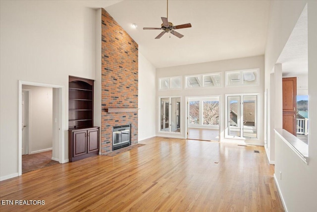 unfurnished living room with plenty of natural light, a fireplace, and light wood finished floors