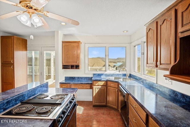 kitchen with dark tile patterned floors, a sink, brown cabinetry, stainless steel electric range oven, and dishwasher