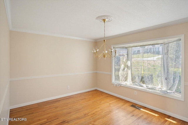 unfurnished dining area featuring visible vents, baseboards, an inviting chandelier, and wood finished floors