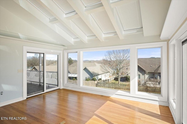 unfurnished sunroom with vaulted ceiling with beams