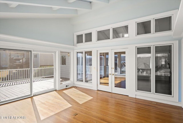 unfurnished sunroom featuring french doors and vaulted ceiling with beams