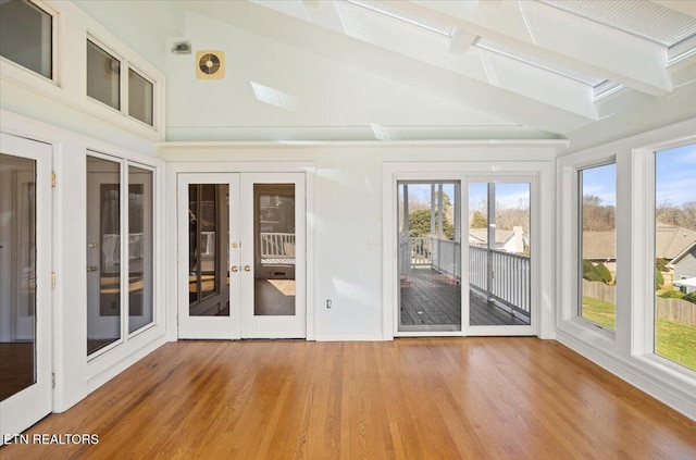 unfurnished sunroom featuring a wealth of natural light, french doors, and lofted ceiling with beams