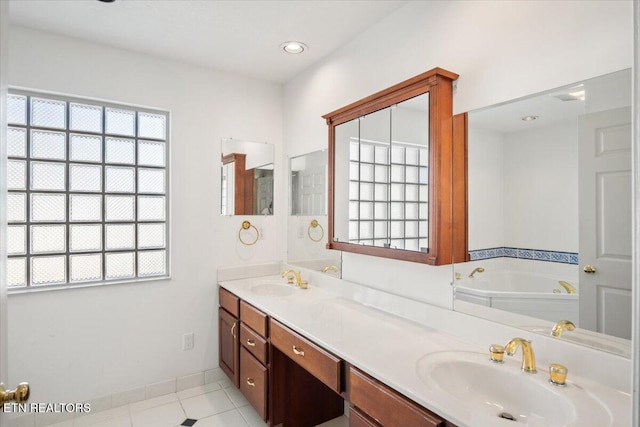 bathroom with double vanity, a bath, baseboards, and a sink