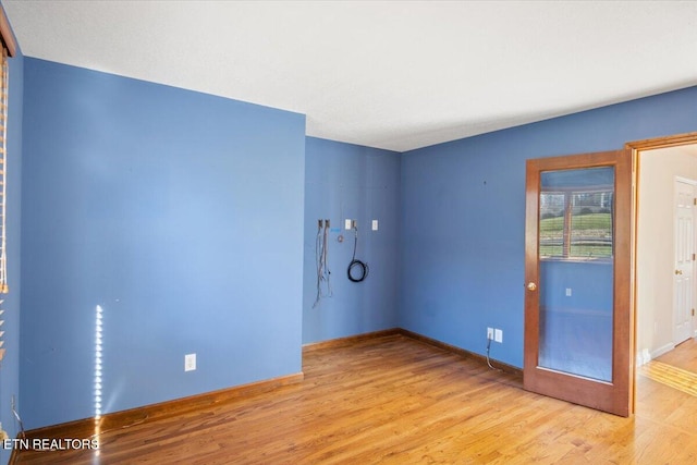 empty room with baseboards and wood finished floors