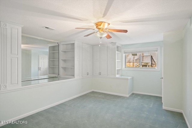 empty room featuring visible vents, a ceiling fan, a textured ceiling, carpet flooring, and baseboards