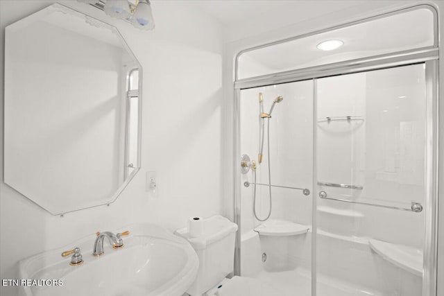 full bathroom featuring a sink, toilet, and a stall shower