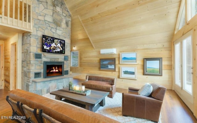 living room featuring high vaulted ceiling, a fireplace, wooden ceiling, a wall unit AC, and light hardwood / wood-style flooring