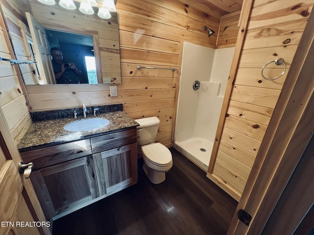 bathroom featuring hardwood / wood-style flooring, vanity, a shower, toilet, and wood walls