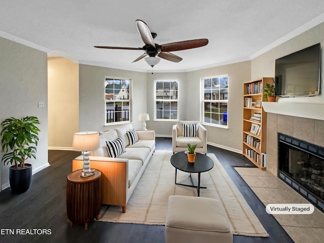 living room featuring crown molding, ceiling fan, and a fireplace