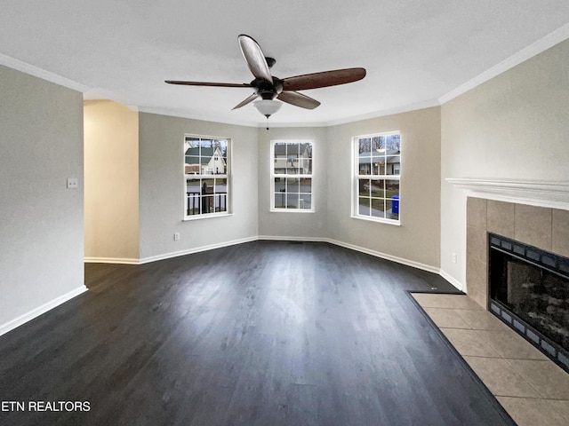 unfurnished living room with dark hardwood / wood-style flooring, ornamental molding, a tile fireplace, and ceiling fan