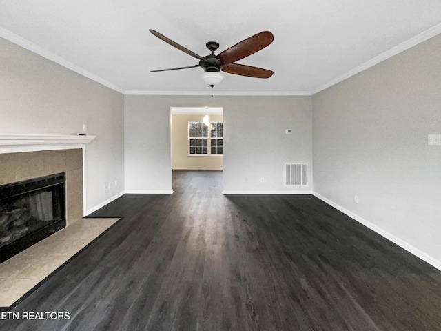 unfurnished living room featuring dark hardwood / wood-style flooring, crown molding, ceiling fan, and a tiled fireplace