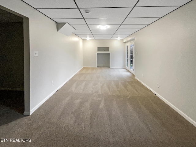 carpeted empty room with a drop ceiling