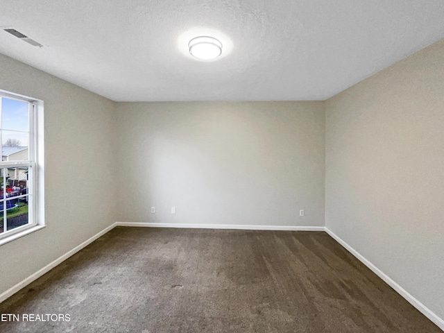 unfurnished room with dark carpet