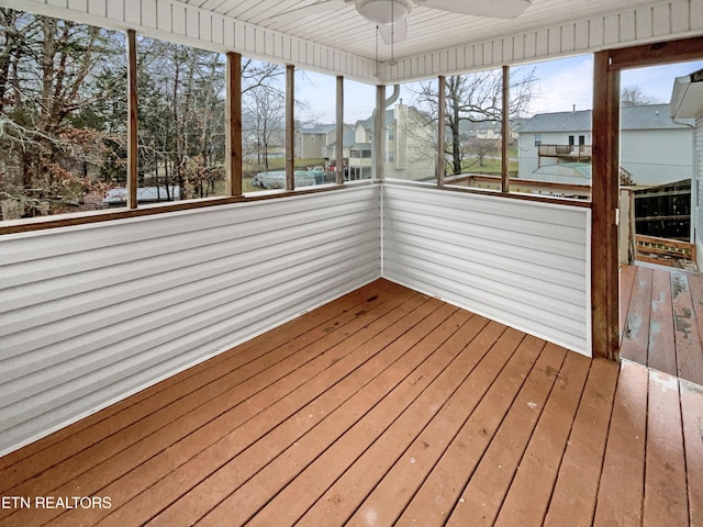 unfurnished sunroom with ceiling fan