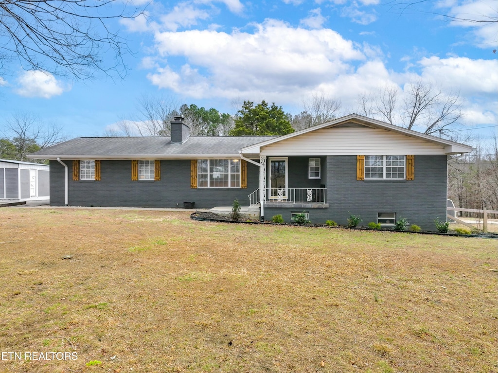 ranch-style house featuring a front yard and covered porch