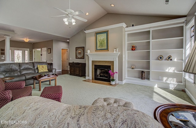 carpeted living room featuring ceiling fan, lofted ceiling, and ornate columns
