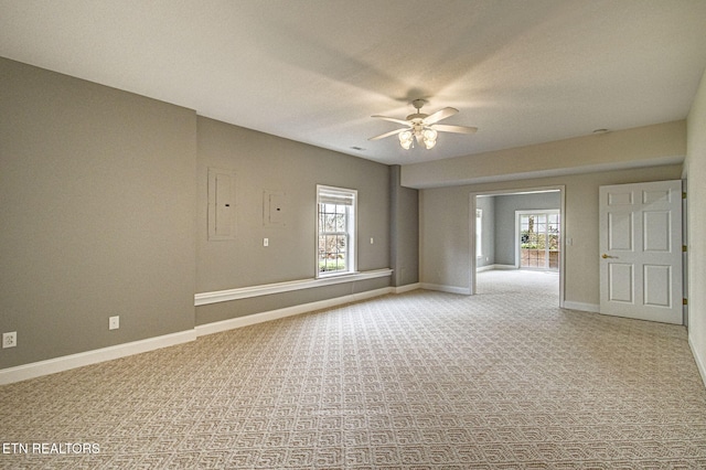 spare room with ceiling fan, electric panel, and carpet