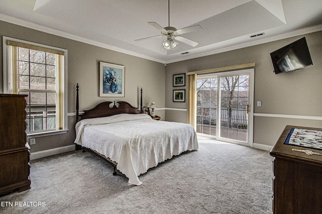 carpeted bedroom featuring ceiling fan, ornamental molding, a tray ceiling, and access to outside