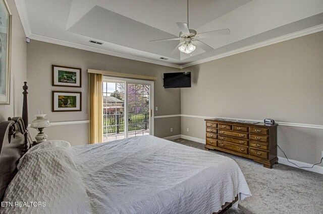 bedroom featuring a tray ceiling, access to outside, ornamental molding, and carpet