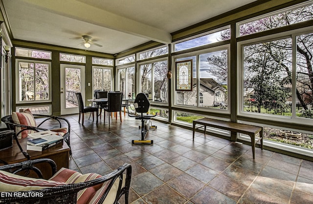 sunroom / solarium featuring beamed ceiling, ceiling fan, and plenty of natural light