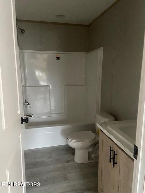 full bathroom featuring vanity, wood-type flooring, tub / shower combination, and toilet