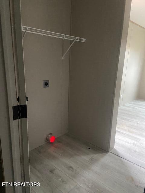 clothes washing area featuring light hardwood / wood-style floors and hookup for an electric dryer