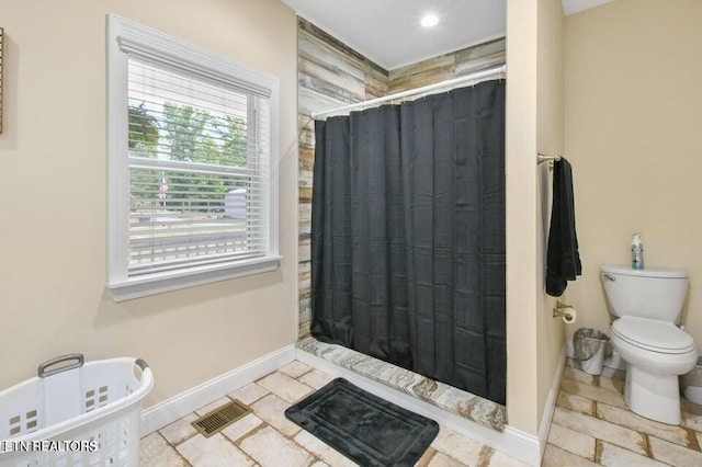 bathroom with toilet and walk in shower