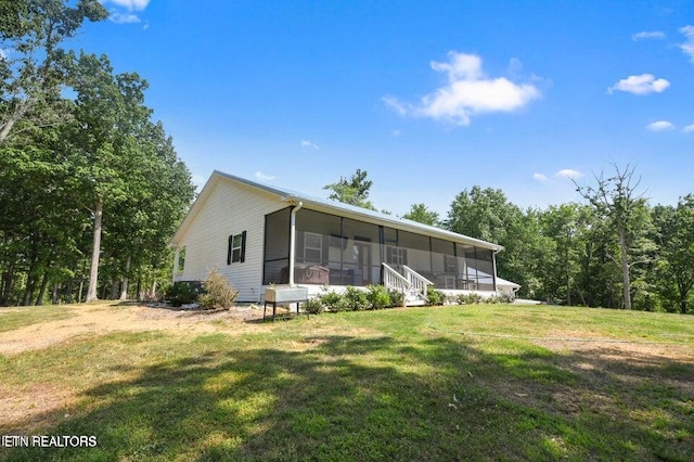 view of front of home featuring a front lawn and a sunroom