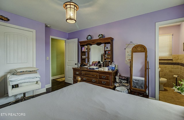 bedroom with tile walls and connected bathroom