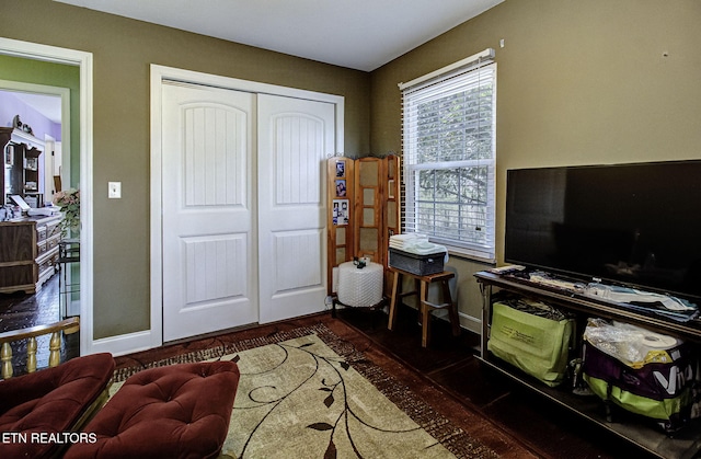 interior space featuring wood finished floors, a closet, and baseboards