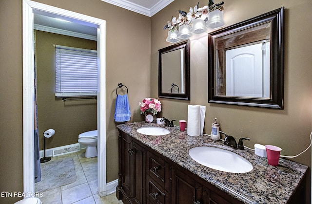 bathroom with double vanity, toilet, crown molding, and a sink