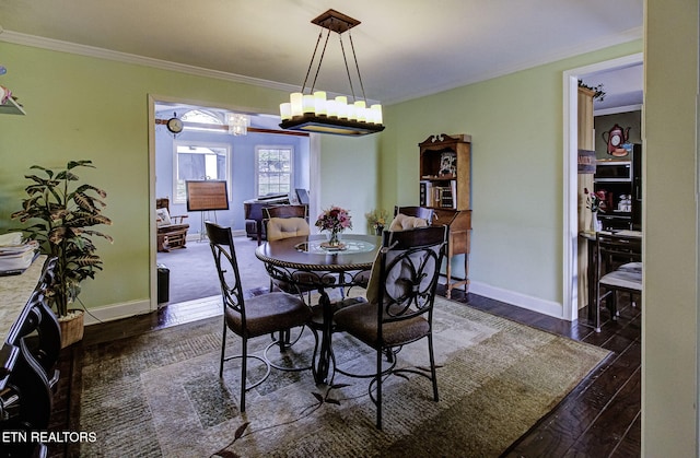 dining area featuring baseboards, crown molding, and hardwood / wood-style flooring