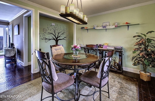 dining space featuring an inviting chandelier, crown molding, baseboards, and wood-type flooring