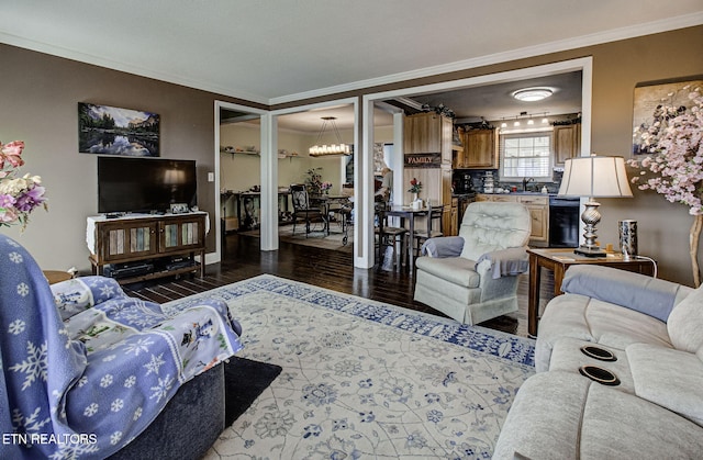 living room with dark wood-style floors, an inviting chandelier, beverage cooler, and ornamental molding