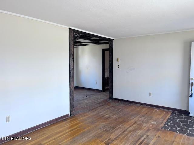 unfurnished room with crown molding and dark hardwood / wood-style floors