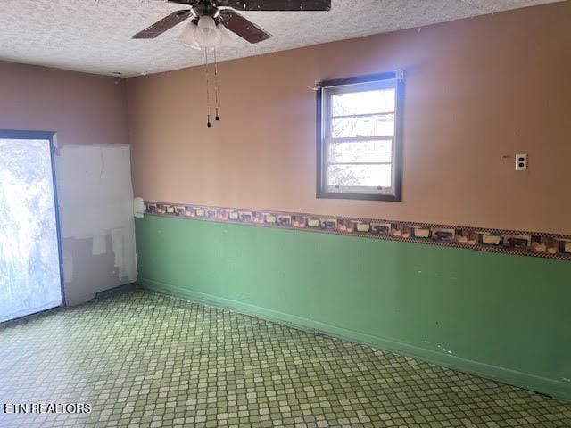 spare room featuring ceiling fan and a textured ceiling