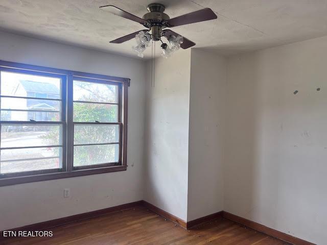 empty room featuring dark hardwood / wood-style flooring and ceiling fan